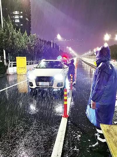 凌晨，東甌大橋卡點(diǎn)處，永嘉縣黨員干部頂風(fēng)冒雨、在嚴(yán)寒中牢牢值守。（　圖片由浙江省溫州市委組織部提供）